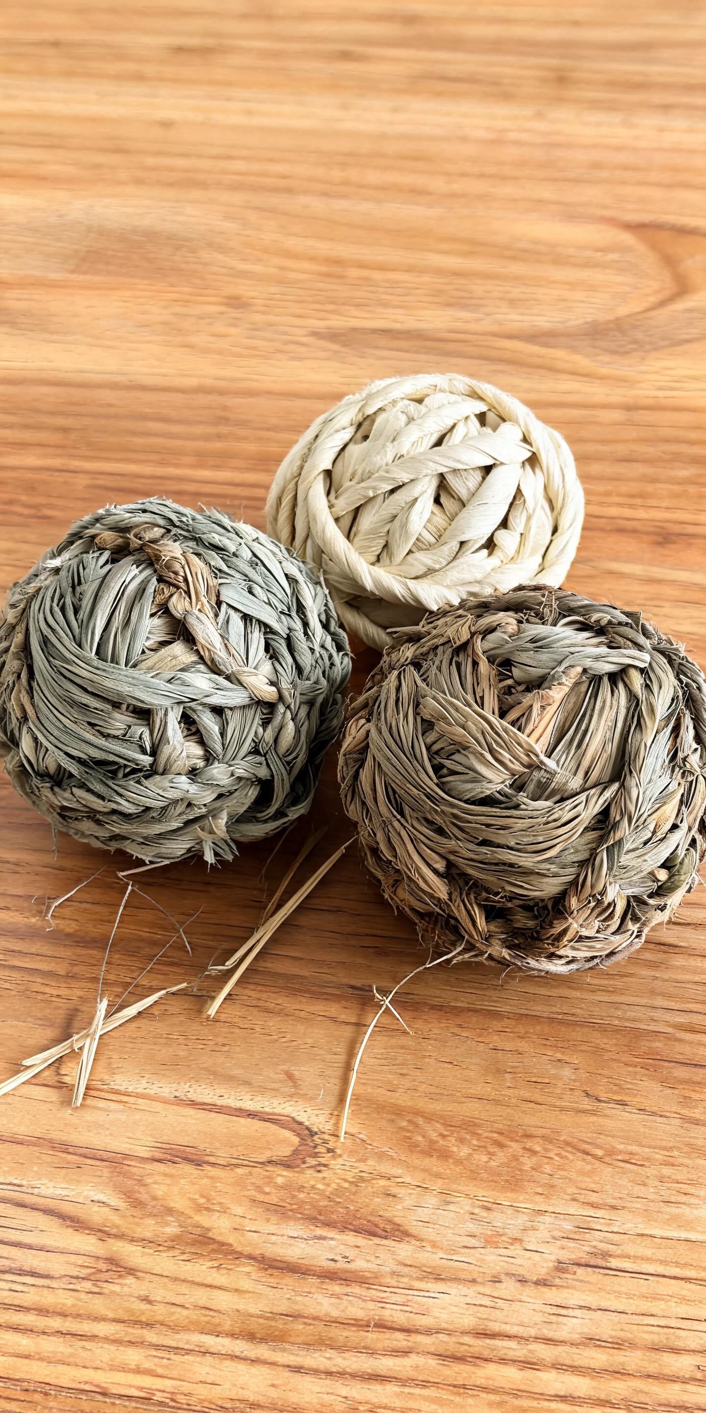 Set of three handwoven natural fiber chew balls for cats and dogs: seagrass, corn husk, and cattail