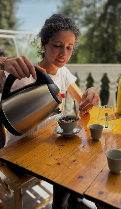 A guest brewing tea in a gaiwan on the porch