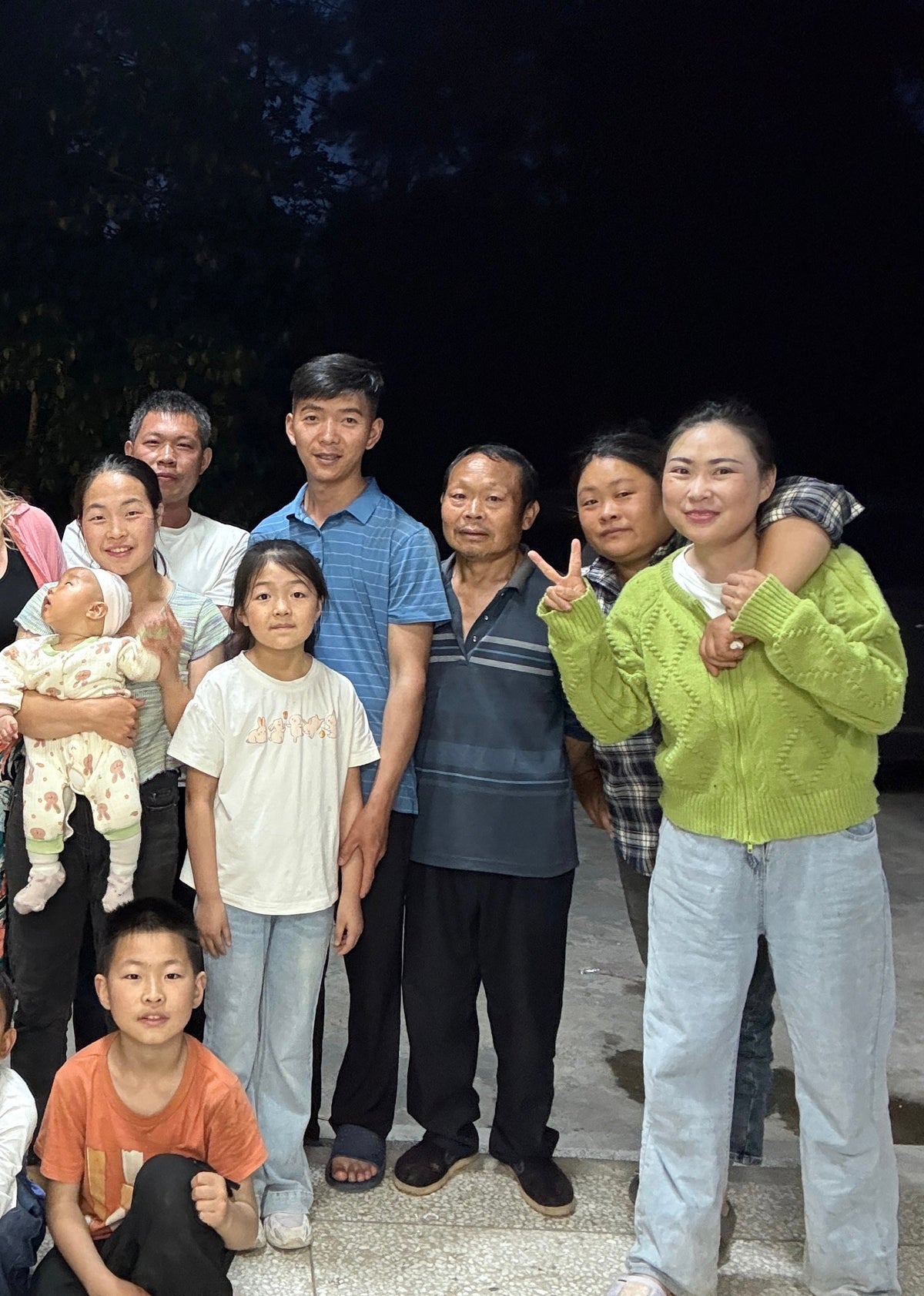 all villagers posing together outdoors at night